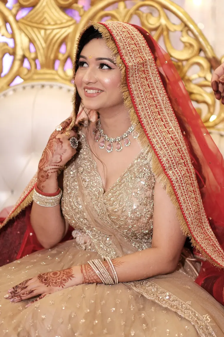 Nishtha smiling beneath a red embroidered dupatta
